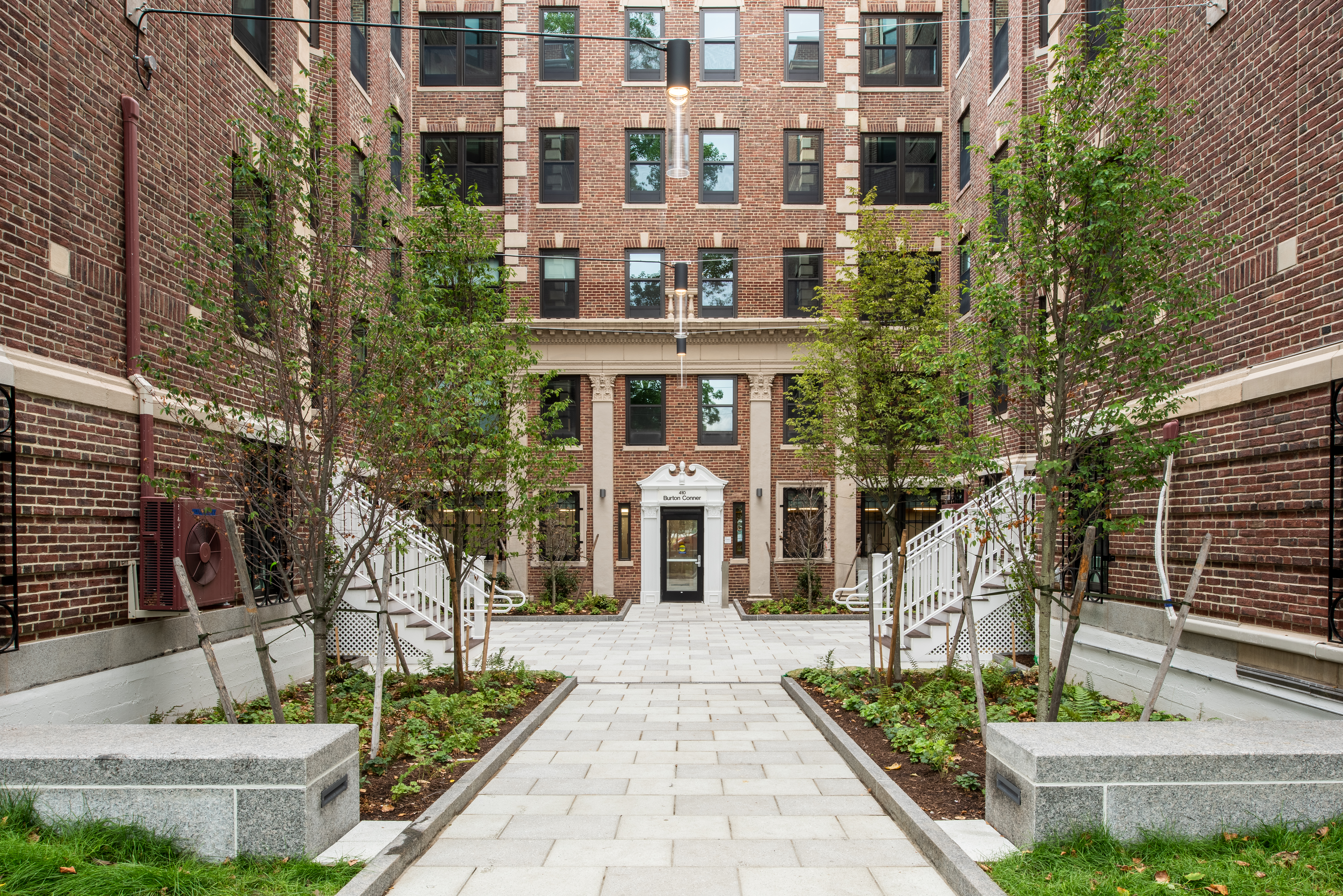 Front entrance of Burton Conner with greenery on either side of door.