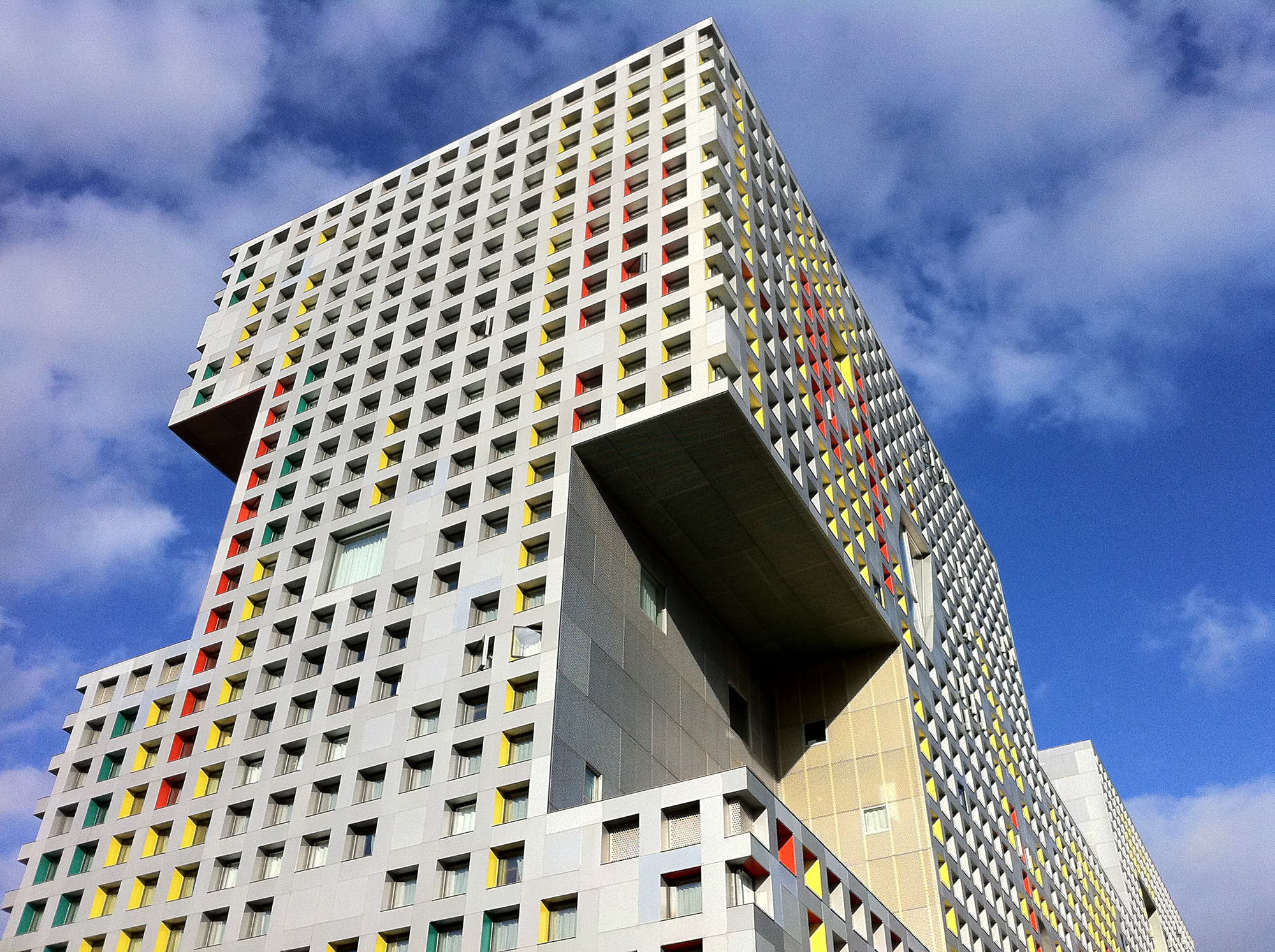 Side of Simmons Hall with many windows covering the size, blue sky with clouds in the background.
